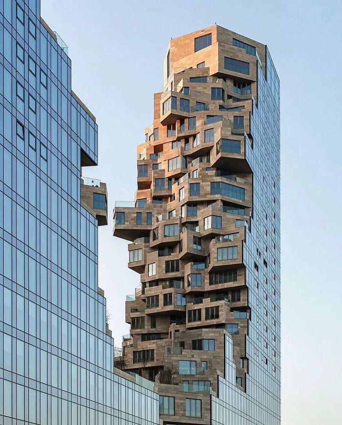 Unique high-rise building with irregular blocks and windows creating a reality glitched effect in architecture.