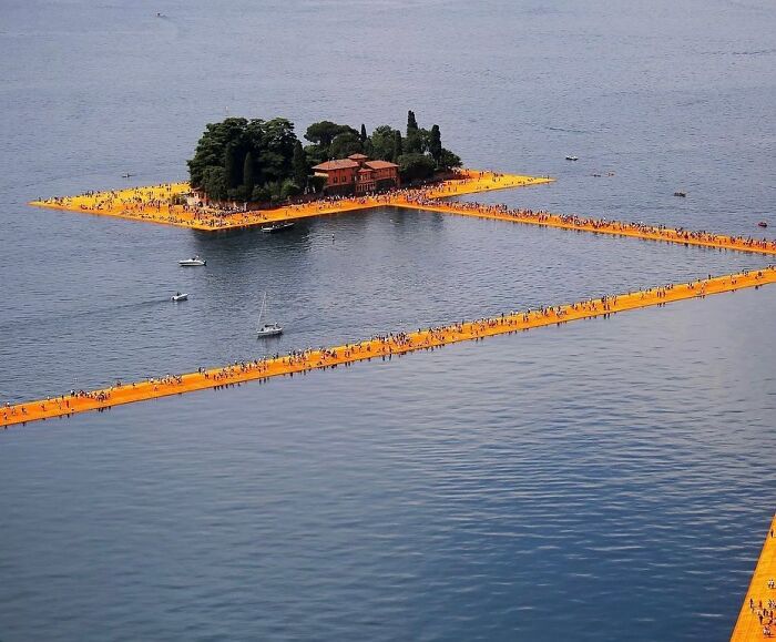 Aerial view of an island connected by bright orange floating walkways, creating a reality glitch illusion with perfectly timed shots.