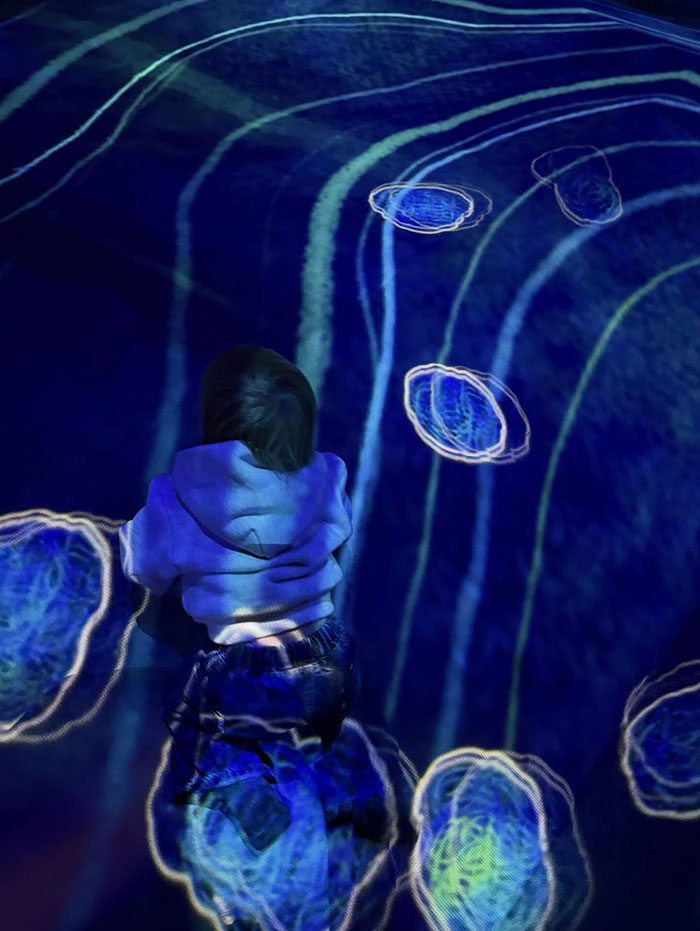 Toddler son crawling on a floor with blue abstract light patterns, relating to pathological liar claim skepticism.