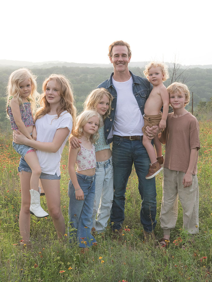 Eric Dane standing in a field with his daughters and sons, all smiling and dressed casually outdoors.