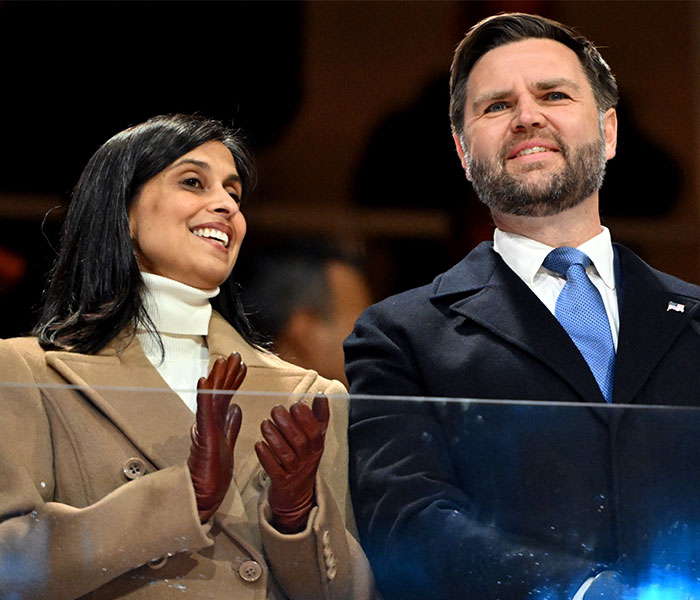 Two spectators dressed warmly, smiling and reacting during the wildest bizarre moments of the 2026 Winter Olympics.