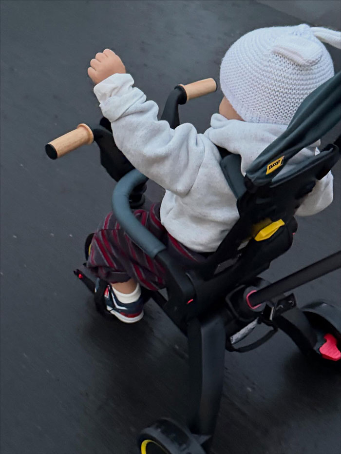 Toddler boy wearing a white knit hat riding a tricycle, illustrating the theme of pathological liar claims about a young child.
