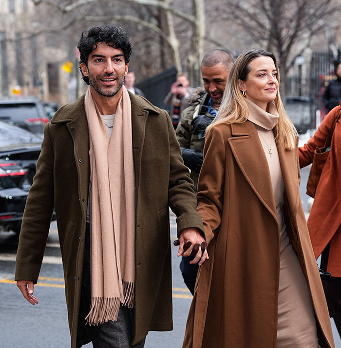 Blake Lively and Justin Baldoni walking outside court, wearing coordinating brown coats, in a hilariously awkward fashion moment.