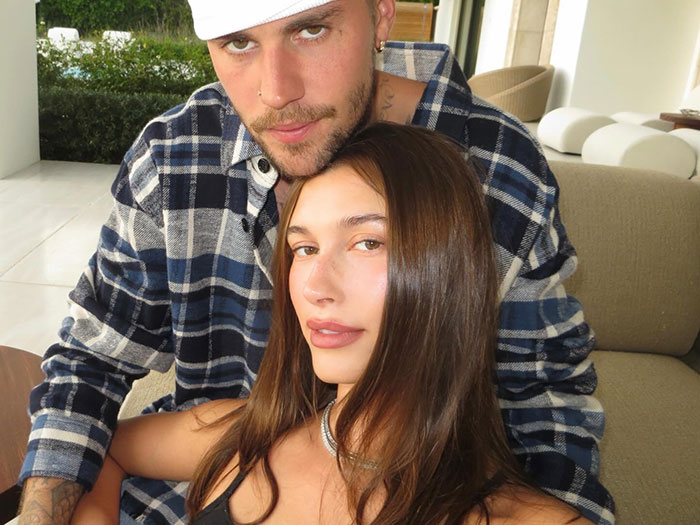 Justin and Hailey Bieber sitting closely, showing a tense moment captured during the Super Bowl event.