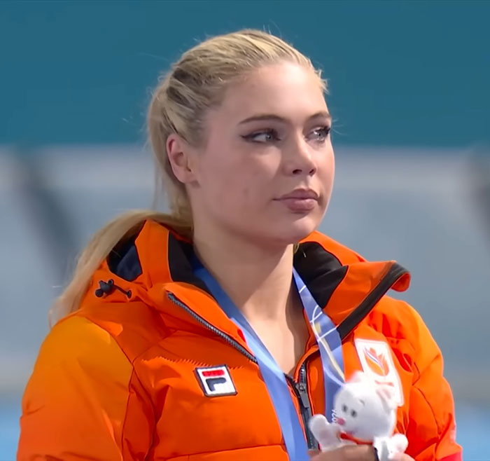 Jutta Leerdam at the Olympics wearing an orange jacket and holding a mascot, fans stunned by potential earnings. Jutta Leerdam at the Olympics wearing an orange jacket and holding a mascot, fans stunned by potential earnings.