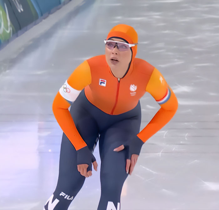 Dutch speed skater Jutta Leerdam competing at the Olympics, wearing orange and navy racing suit. Dutch speed skater Jutta Leerdam competing at the Olympics, wearing orange and navy racing suit.