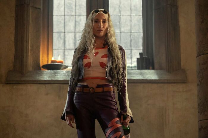 Woman with long silver hair and purple outfit standing in a dimly lit room, related to One Piece season 2 casting choice debate. - 1