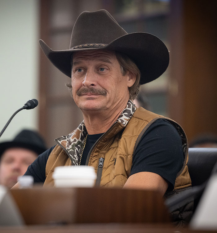 Man in cowboy hat and brown vest sitting indoors, related to RFK Jr. workout video sparking wild reactions. Man in cowboy hat and brown vest sitting indoors, related to RFK Jr. workout video sparking wild reactions.