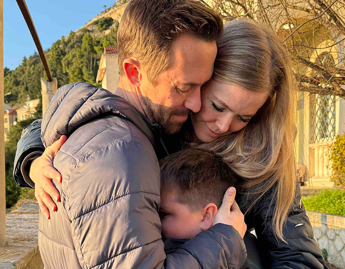 Family reunited outdoors, emotional hug showing relief and love after four missing kids returned to dad from foreign orphanage.