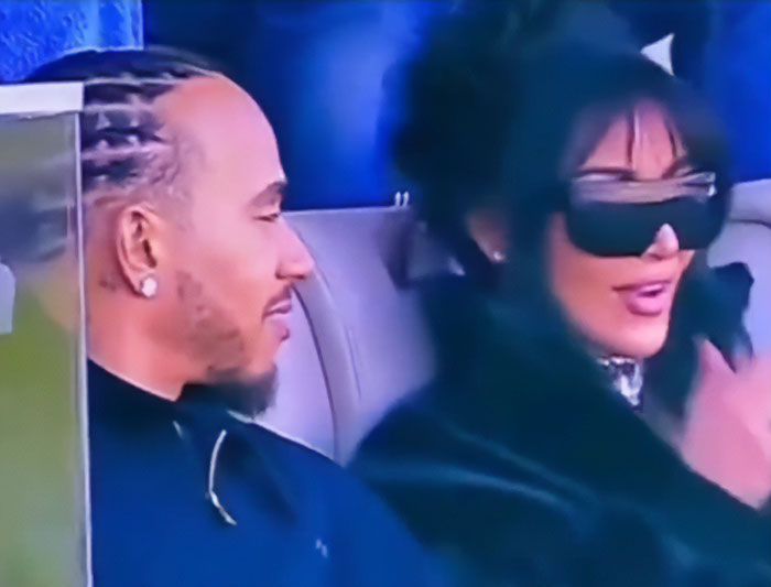 Lewis Hamilton and Kim Kardashian displaying tightly controlled body language moves during a public appearance.