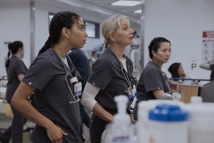 Three nurses in hospital scrubs observing a patient area, scene from The Pitt Season 2 Episode 7 hospital drama. Three nurses in hospital scrubs observing a patient area, scene from The Pitt Season 2 Episode 7 hospital drama.