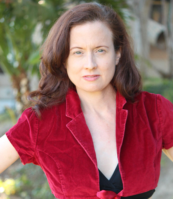 Woman in a red velvet jacket posing outdoors, related to Grey's Anatomy actress Eric Dane bullying claim controversy.