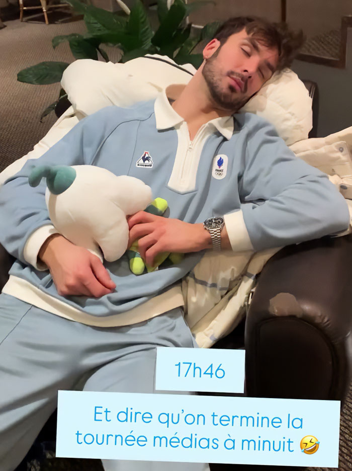 French skater resting on a couch holding a plush toy after a suspicious Olympic win amid cheating scandal.