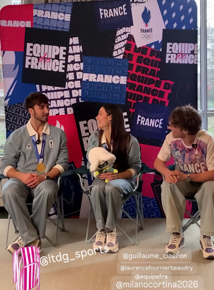 Three athletes in France team outfits seated in front of a backdrop, discussing French skater and Olympics cheating scandal.