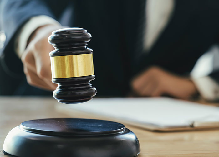 Judge using gavel in courtroom representing divorce lawyers handling difficult and haunting legal cases.