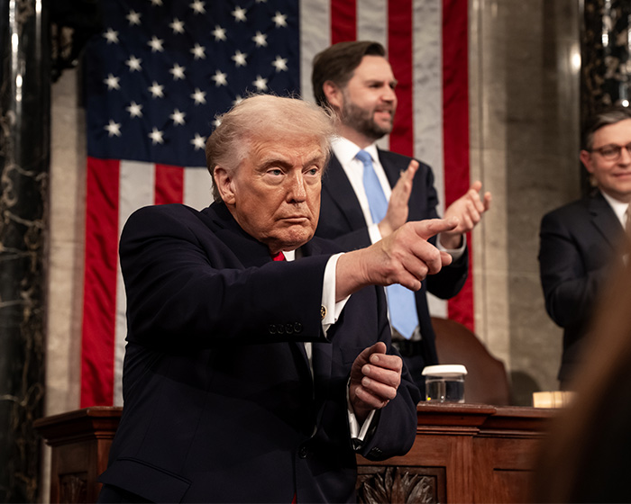Former President Donald Trump pointing during a State of the Union with people applauding in the background.