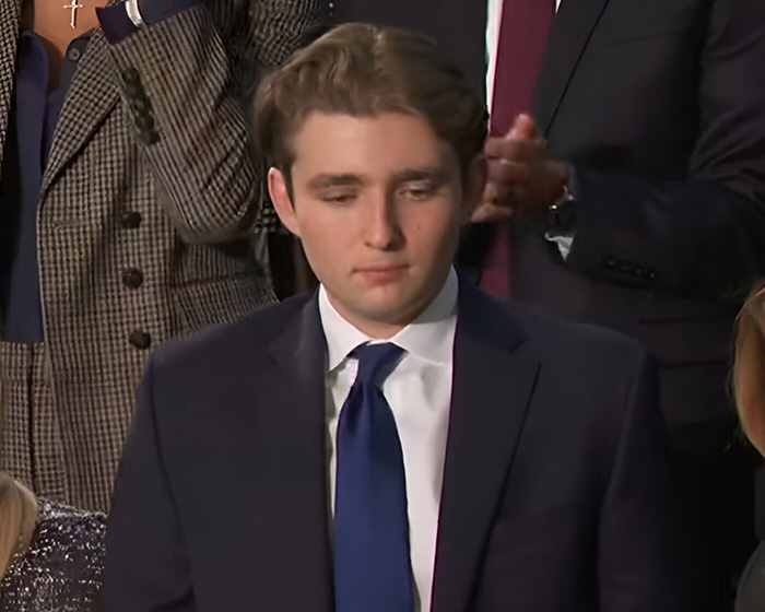 Young man in a dark suit and blue tie at an event, relevant to lip reader claims about rude words Barron told Ivanka.