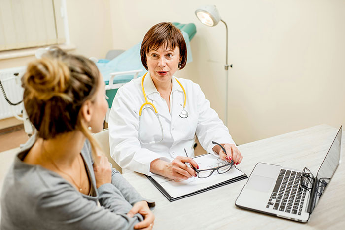 Female doctor consulting a patient in a medical office highlighting issues of medical misogyny and women’s health risk.