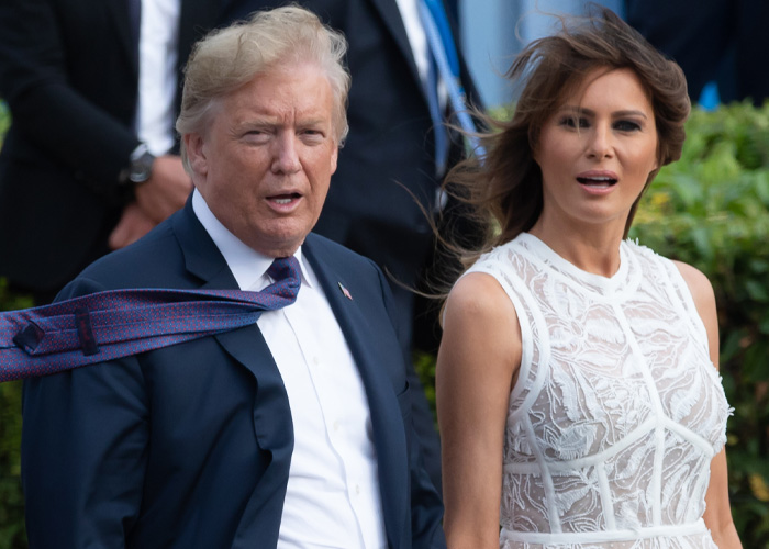 Melania Trump’s polished appearance disrupted by wind revealing unexpected details while standing beside Donald Trump outdoors.