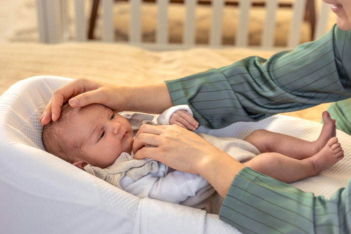 New parents gently comforting their baby in a crib amidst a stressful situation involving false CPS accusations. New parents gently comforting their baby in a crib amidst a stressful situation involving false CPS accusations.