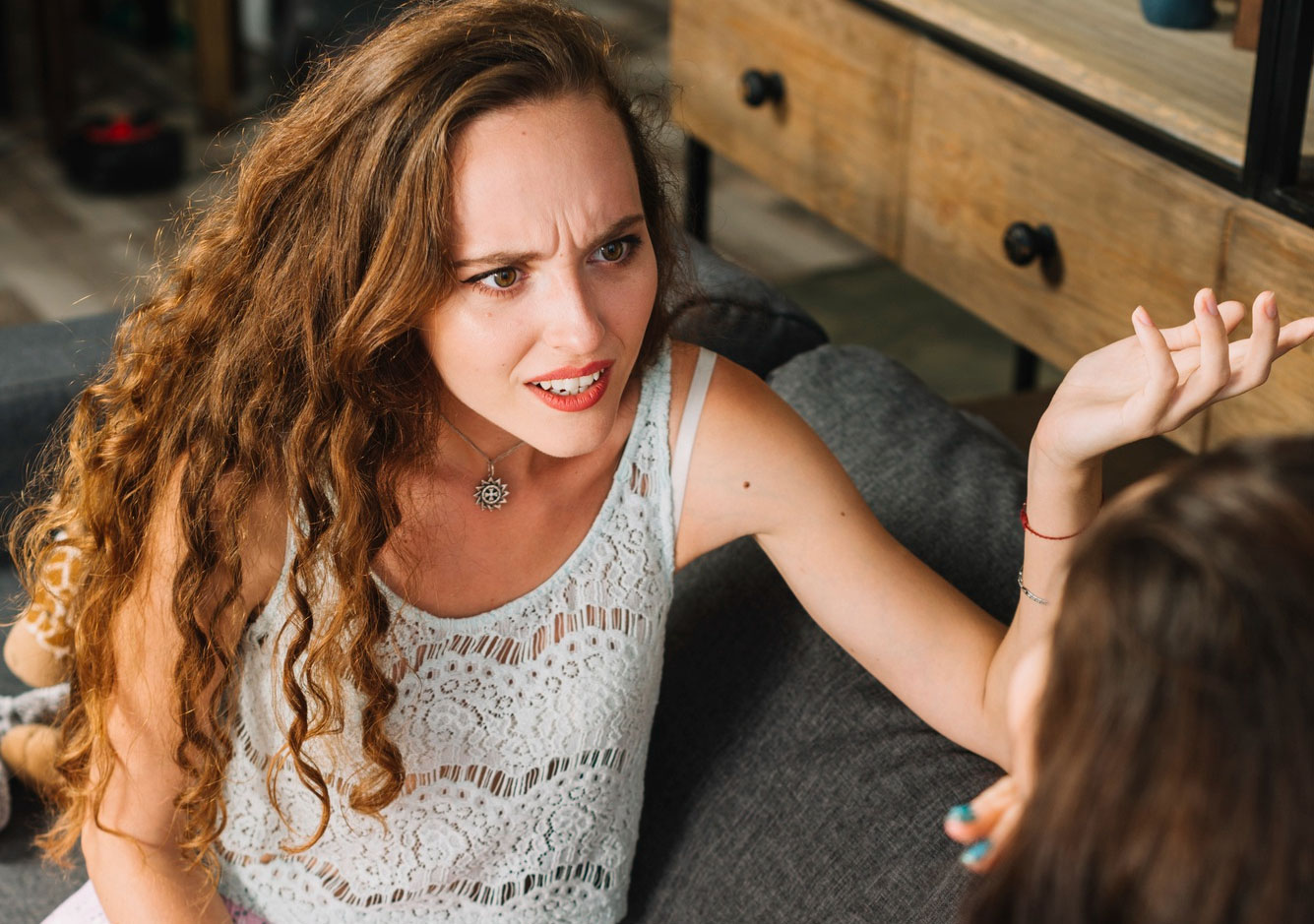 Woman pushes back during a tense conversation with mother-in-law about knowing her husband better at a casual home setting