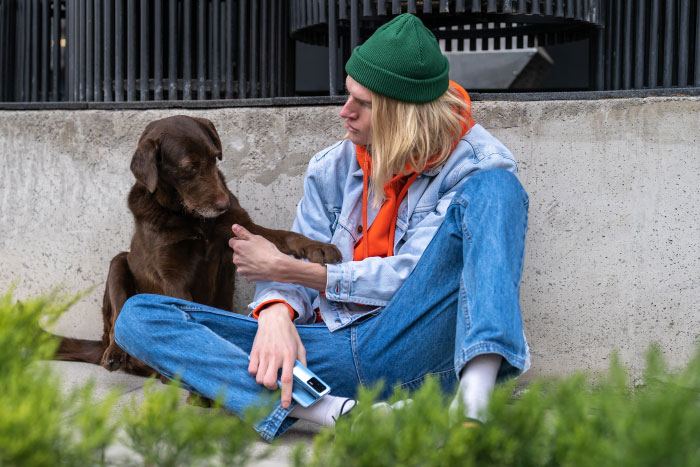 Young person in casual clothes sitting with a brown dog, illustrating MIL pretending dog passed away to get rid of him