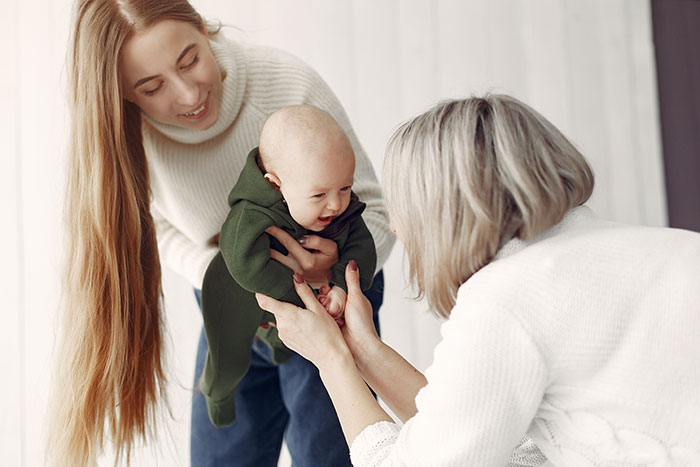 Mother-in-law and daughter-in-law interacting with baby, highlighting concerns about keeping meds out of kid's reach.