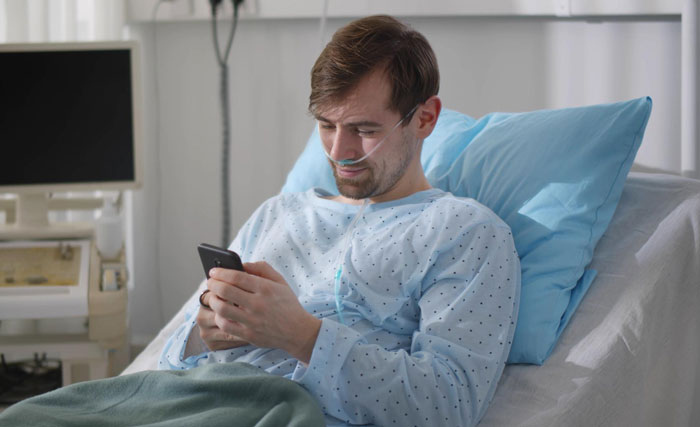 A terminally ill man in hospital bed using a smartphone, reflecting on his mother-in-law's harsh ultimatum.