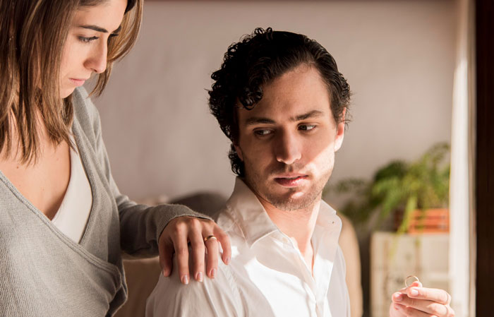 A concerned woman comforting a pensive man, illustrating family dynamics involving a mother-in-law and a terminal son.