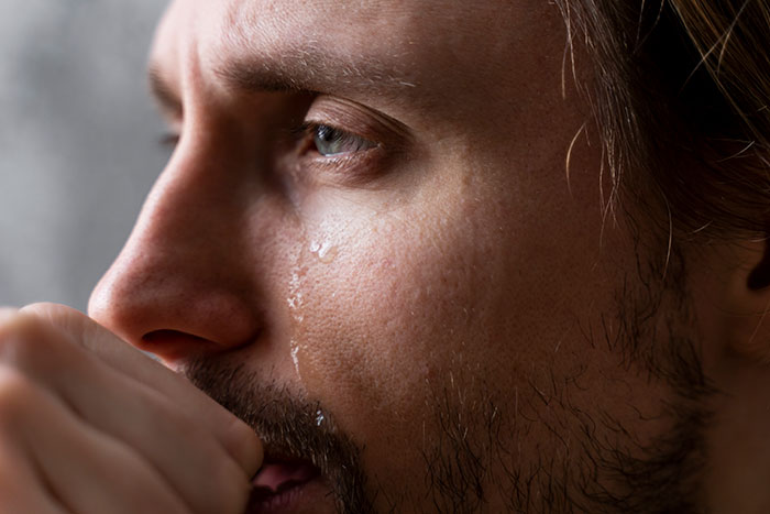 Close-up of a man with a tear on his cheek, reflecting emotional drama related to man date single mom challenges.