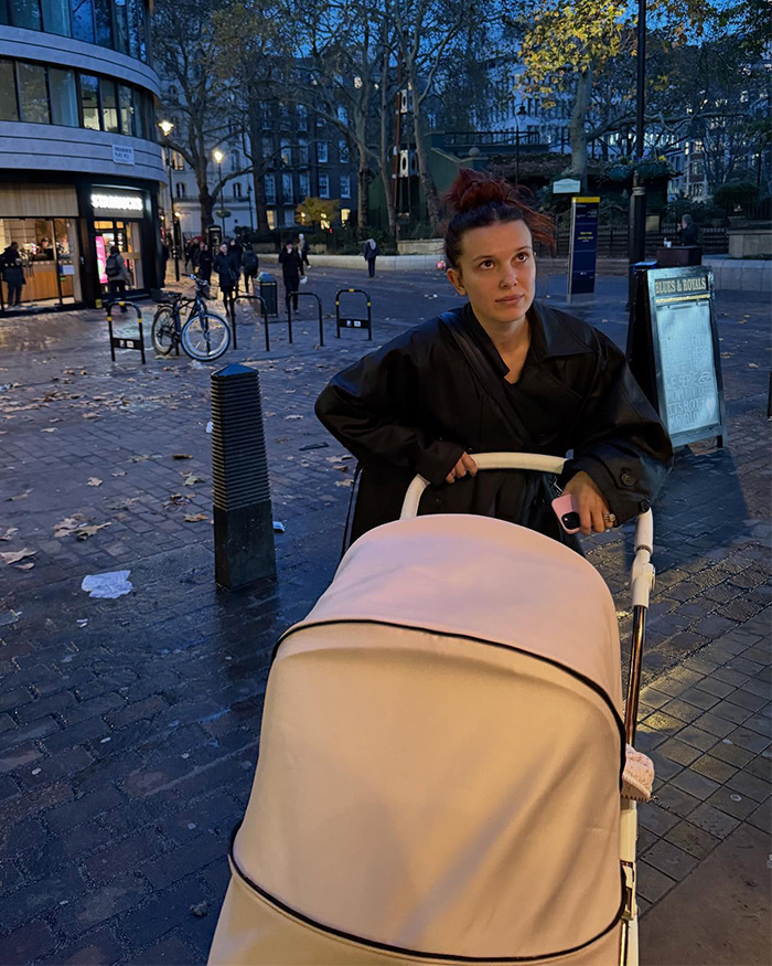 Millie Bobby Brown pushing a stroller outside in the evening, sharing a rare photo of her baby daughter.