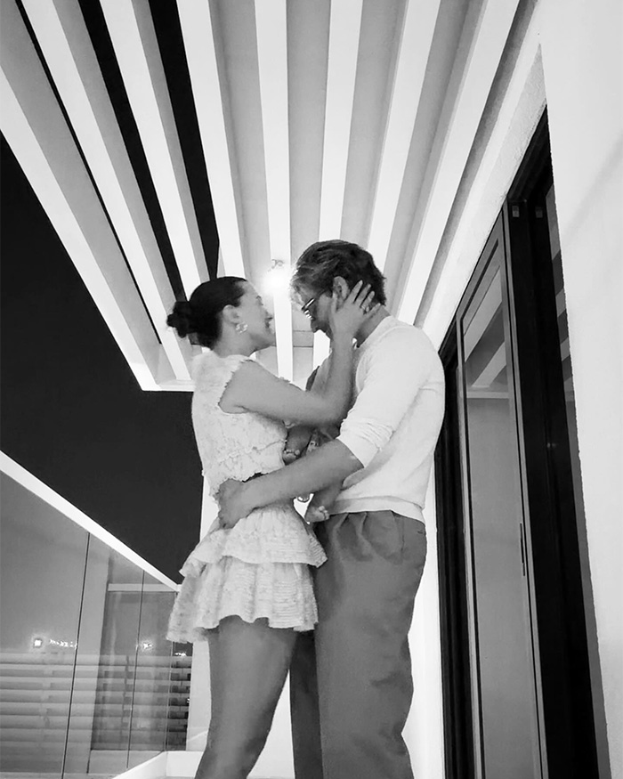 Millie Bobby Brown and partner sharing a tender moment while holding their baby daughter at home.