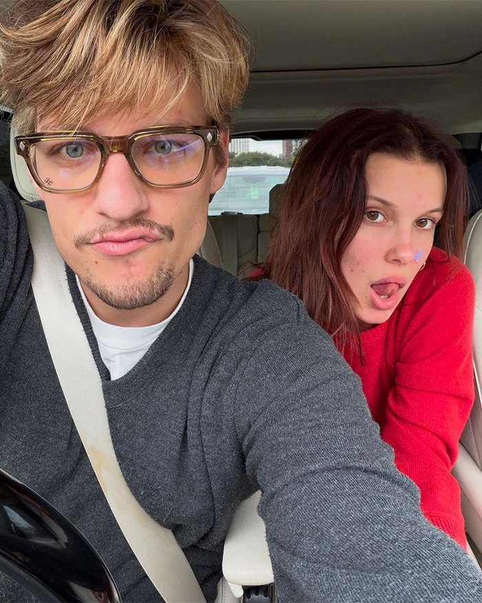 Millie Bobby Brown and a man taking a selfie inside a car, related to sharing photo of her baby daughter news.