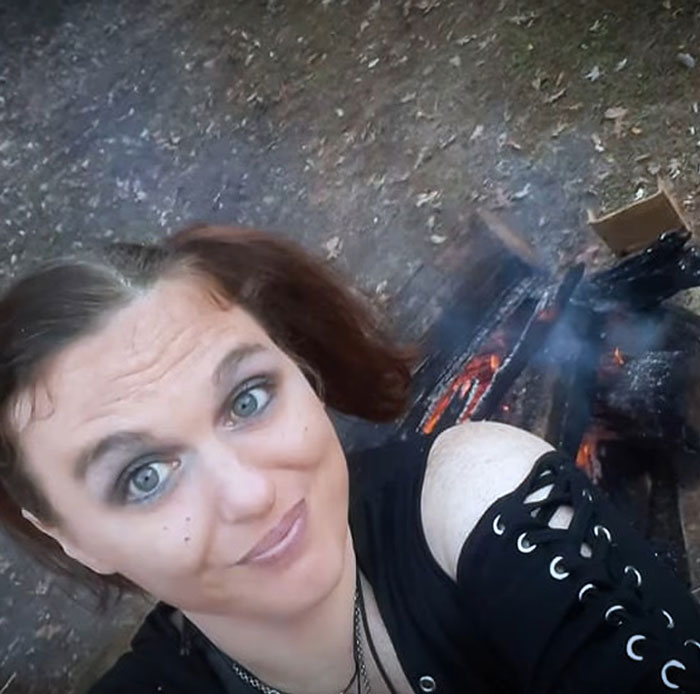 Woman with dark hair and makeup taking a selfie near a campfire amid stunning twist mom vanished 25 years ago.
