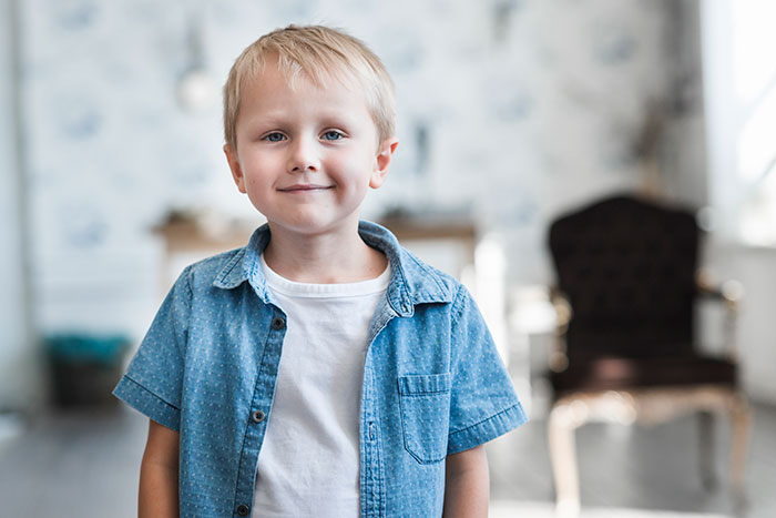 Young boy standing indoors, representing students who shared disturbing things with teachers in a confidential setting