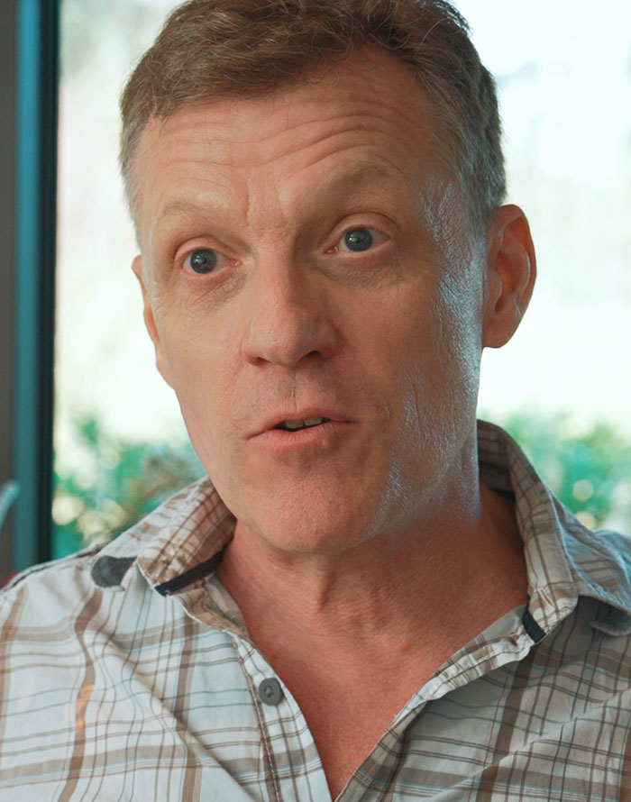 Middle-aged male teacher in a plaid shirt sharing disturbing things students confided in him during an interview.