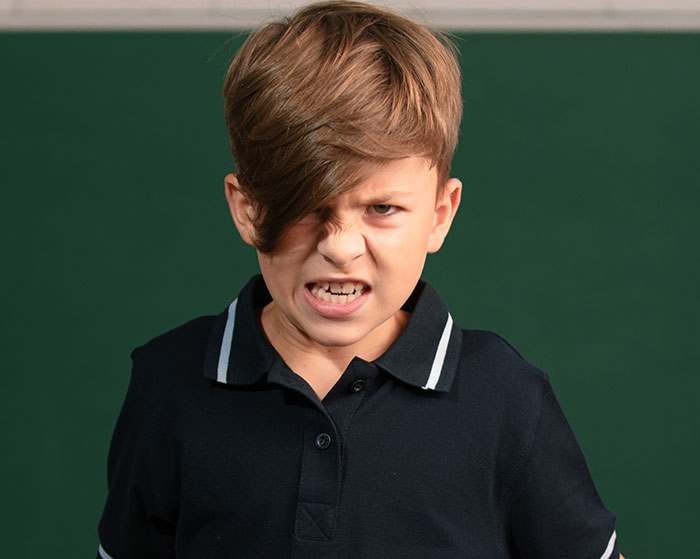 Angry young student in a black shirt with a fierce expression, relating to disturbing things students confided in teachers.