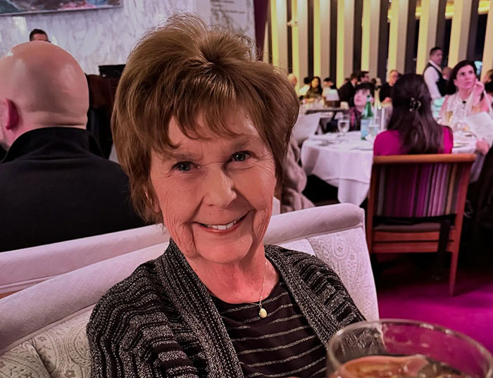 Older woman smiling in a restaurant setting, relevant to Savannah Guthrie missing mom and suspects number one and two case.