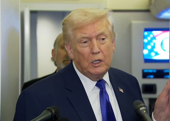 Man in suit and blue tie speaking into microphones, related to neighbor of Nancy Guthrie sharing crucial information.