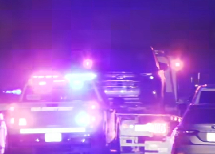 Police vehicles with flashing lights at night during a roof search triggered by neighbor of Nancy Guthrie’s report.