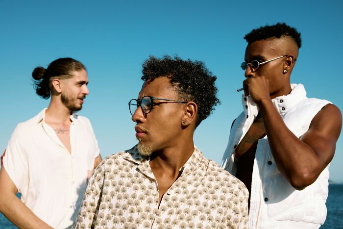 Three young men outdoors looking away from each other, illustrating friendships ended without even starting.