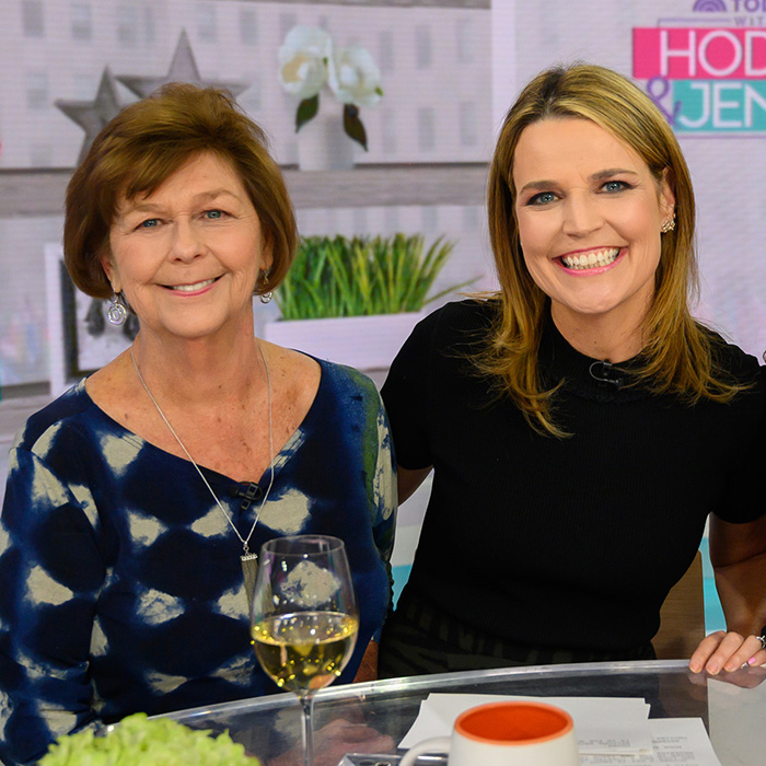 Two women smiling in a TV studio, with plants and decor in the background, unrelated to Nancy Guthrie suspect images.