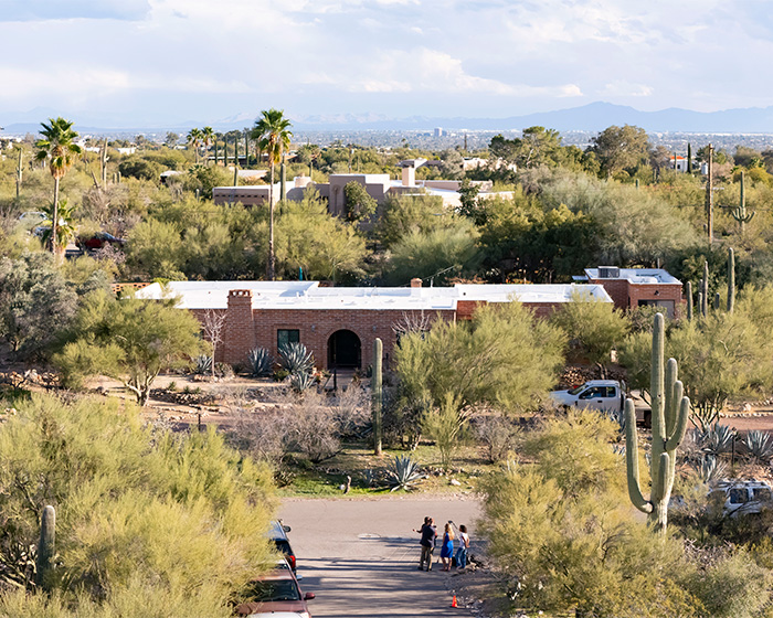Aerial view of a desert neighborhood with people gathered on the street, related to Nancy Guthrie suspect images released.