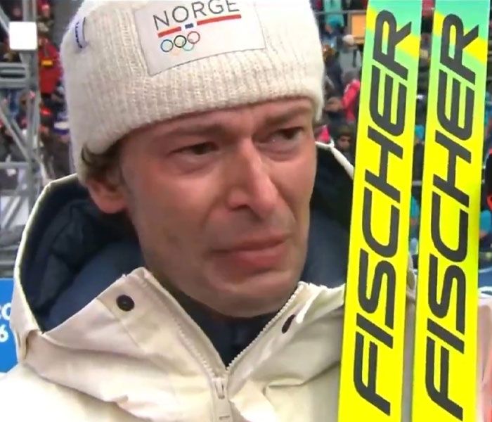 Norwegian ski jumper wearing winter gear holding bright yellow Fischer skis during 2026 Winter Olympics bizarre moments.