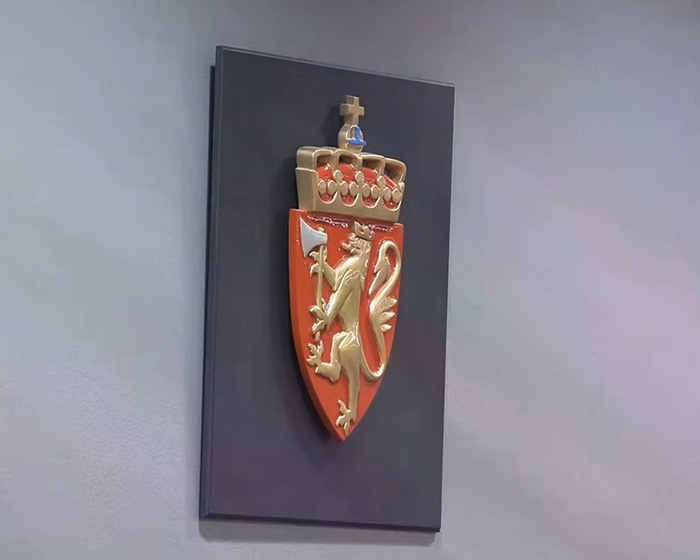 Norwegian royal crest mounted on wall representing son of Norway's crown princess heading to court on charges.