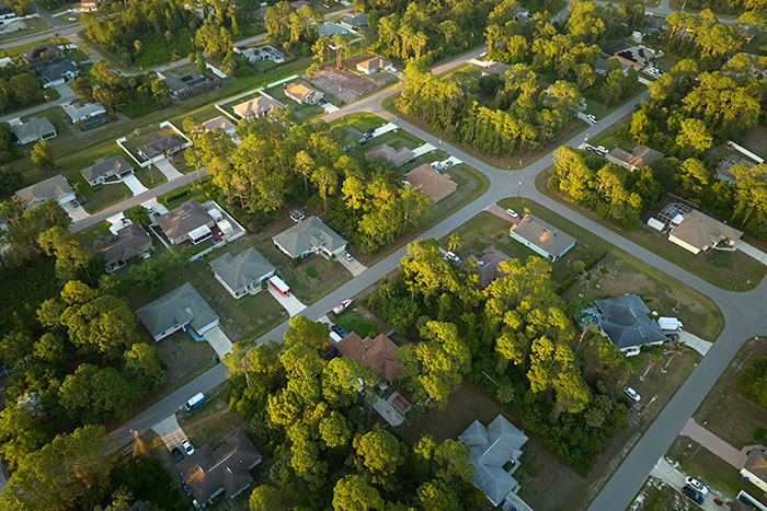 Aerial view of a suburban neighborhood with houses and tree-lined streets, illustrating a neighborly setting.