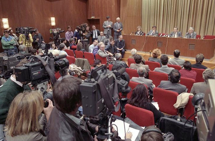 Powerful photo of a crowded press conference with journalists and cameras capturing the event from around the world.