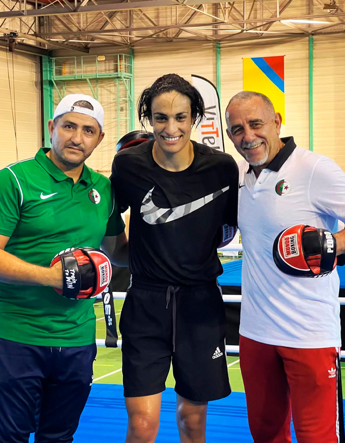 Imane Khelif posing with coaches in a gym, highlighting controversy over Y chromosome gene in sports.