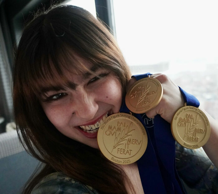 US figure skater showing broken gold medal during celebration at 2025 World Figure Skating Championships in Boston.
