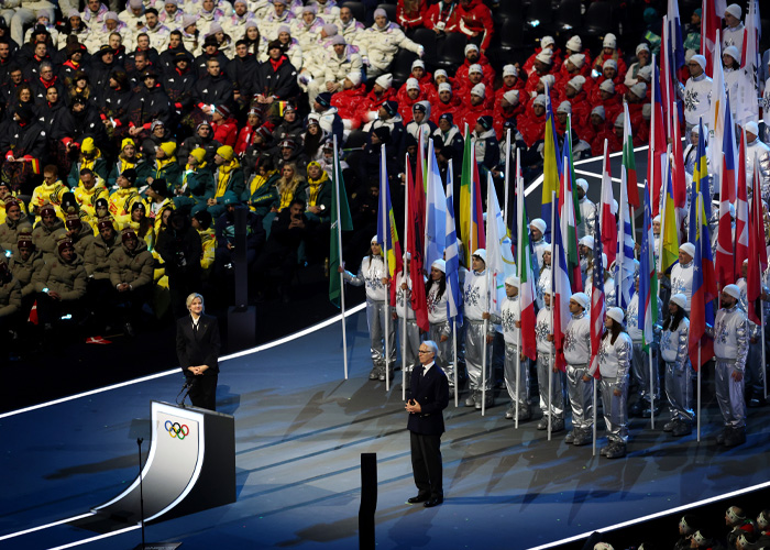 Olympic Village scene with athletes and flag bearers amid talks of condoms running out in three days during the event.